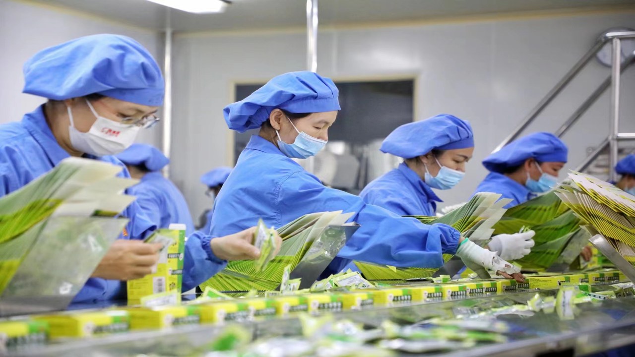 超过一半的供应处于亏损状态,工厂车间里工人正在打包产品,旁边贴着降价通知单