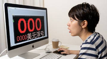 一个年轻人在电脑前看着屏幕上显示的000美元浮亏红色数字,表情惊讶,桌上放着手机和咖啡杯,画面带