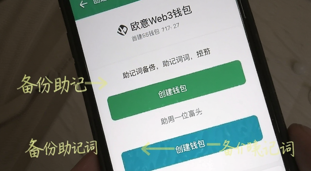 欧意Web3钱包创建界面截图,手机屏幕上显示创建钱包按钮和助记词备份提示,标注“创建钱包”和“备份助记词”文字
