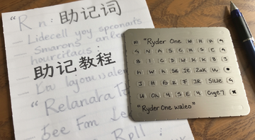 手抄助记词在纸上旁边放着金属助记词板提示词包含Ryder One钱包私钥保护教程文字用引号注明